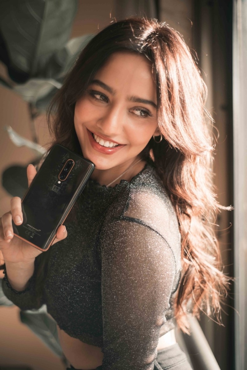 Neha Sharma in black posing for OnePlus 7T Pro Mclaren edition influencer campaign